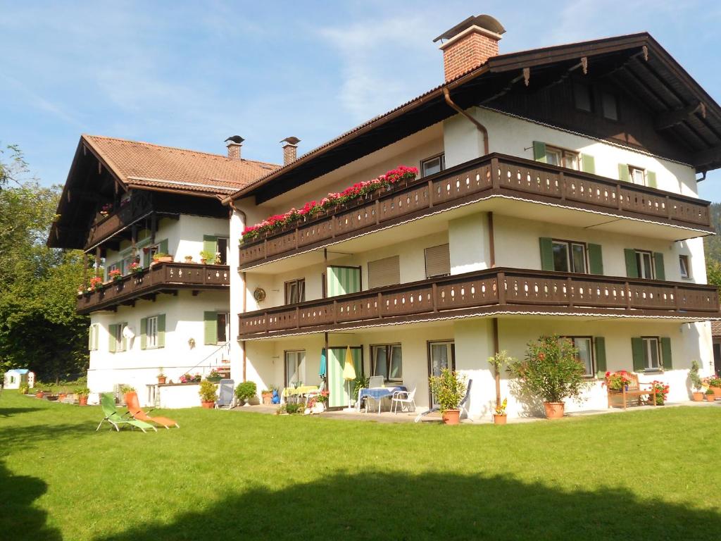 ein großes Gebäude mit Balkonen und Blumen darauf in der Unterkunft Ferienwohnungen Maria in Rottach-Egern