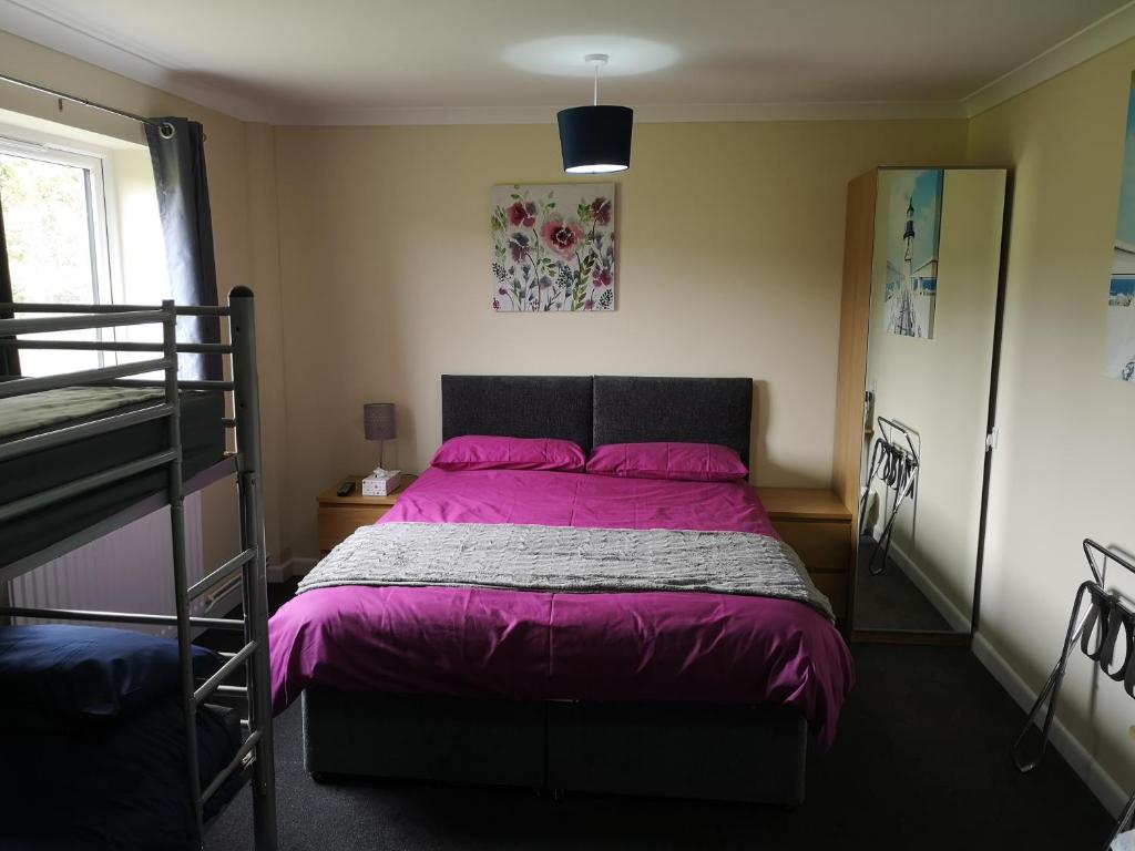 1 dormitorio con 1 cama con edredón morado en Honeysuckle Homestead, en Dinton