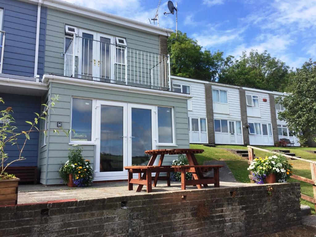 a house with a picnic table in front of it at Freshwater Bay Holiday Cottages in Pembroke