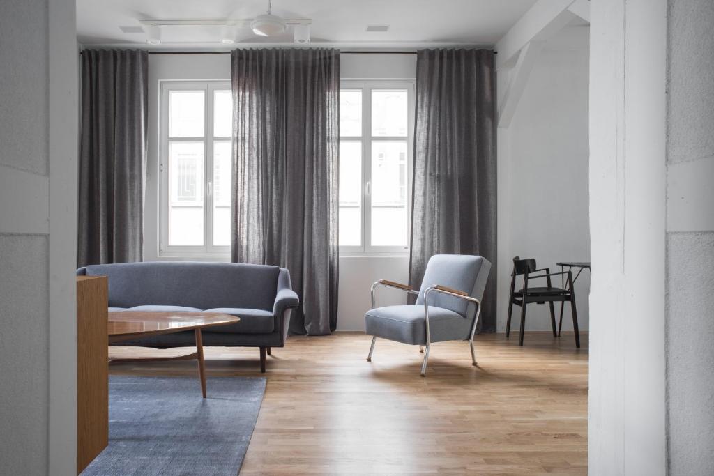 uma sala de estar com duas cadeiras e um sofá em Apartament Ludowa 4 Miedzyzdroje em Międzyzdroje