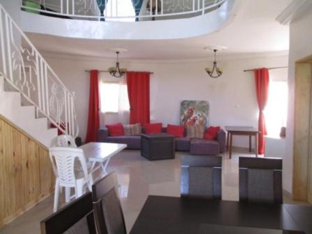 a living room with red curtains and a couch at Villa case authentique , in Saly Portudal