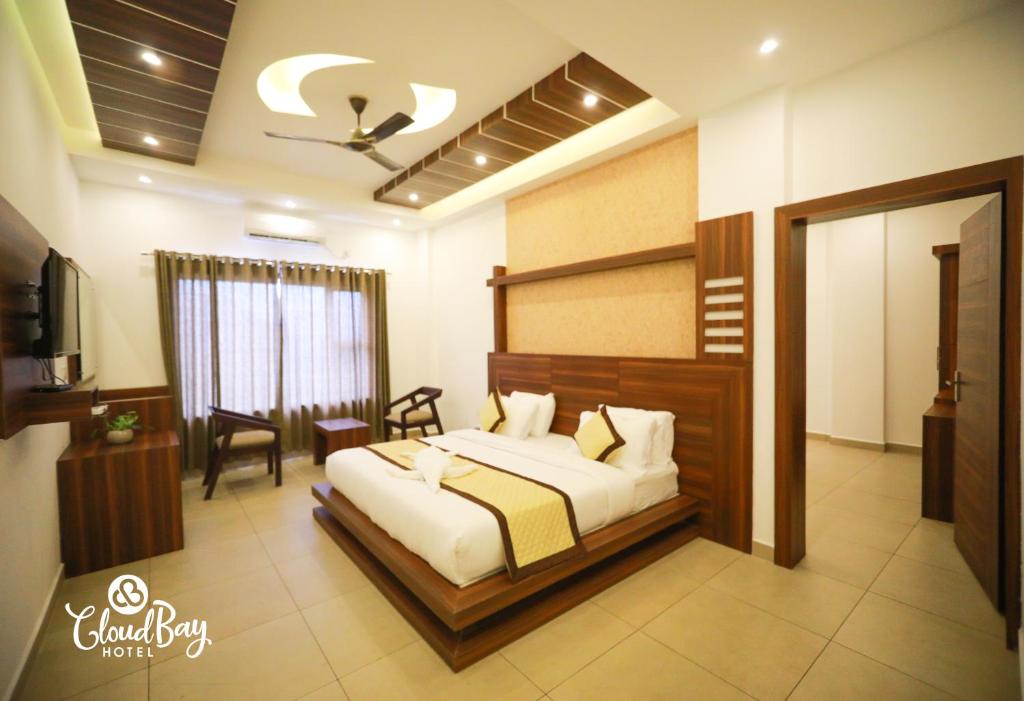 a bedroom with a bed and a television in a room at Hotel CloudBay in Kattappana