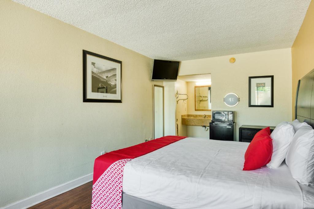 a bedroom with a large bed with red pillows at Hotel Belair Orlando Near Florida Mall in Orlando