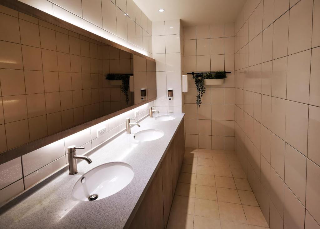 a bathroom with two sinks and a large mirror at Bluewater Hotel Xpark Gloria Outlets Taoyuan Baseball Stadium in Dayuan