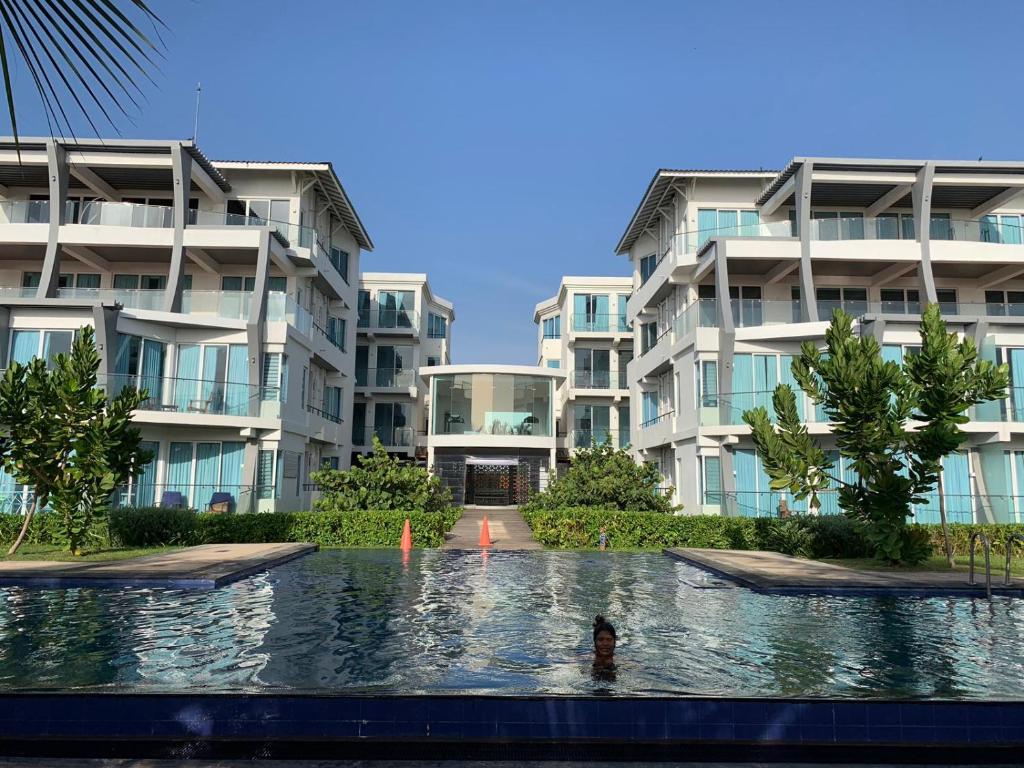 a swimming pool in front of some apartment buildings at 123 Ocean Front Condo in Nilaveli