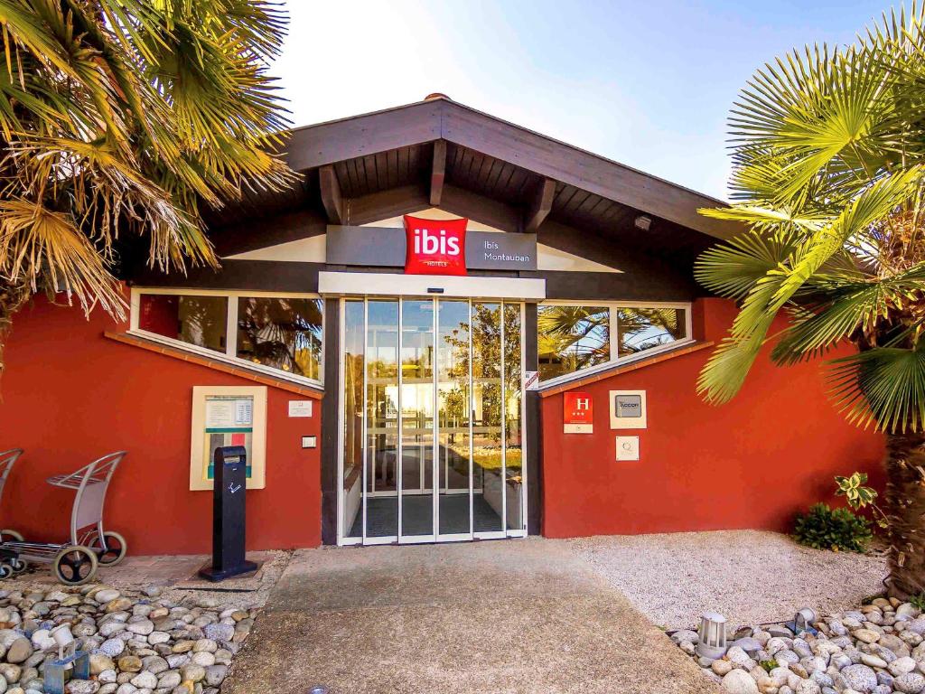 a red building with a ups entrance with a parking meter at ibis Montauban in Montauban