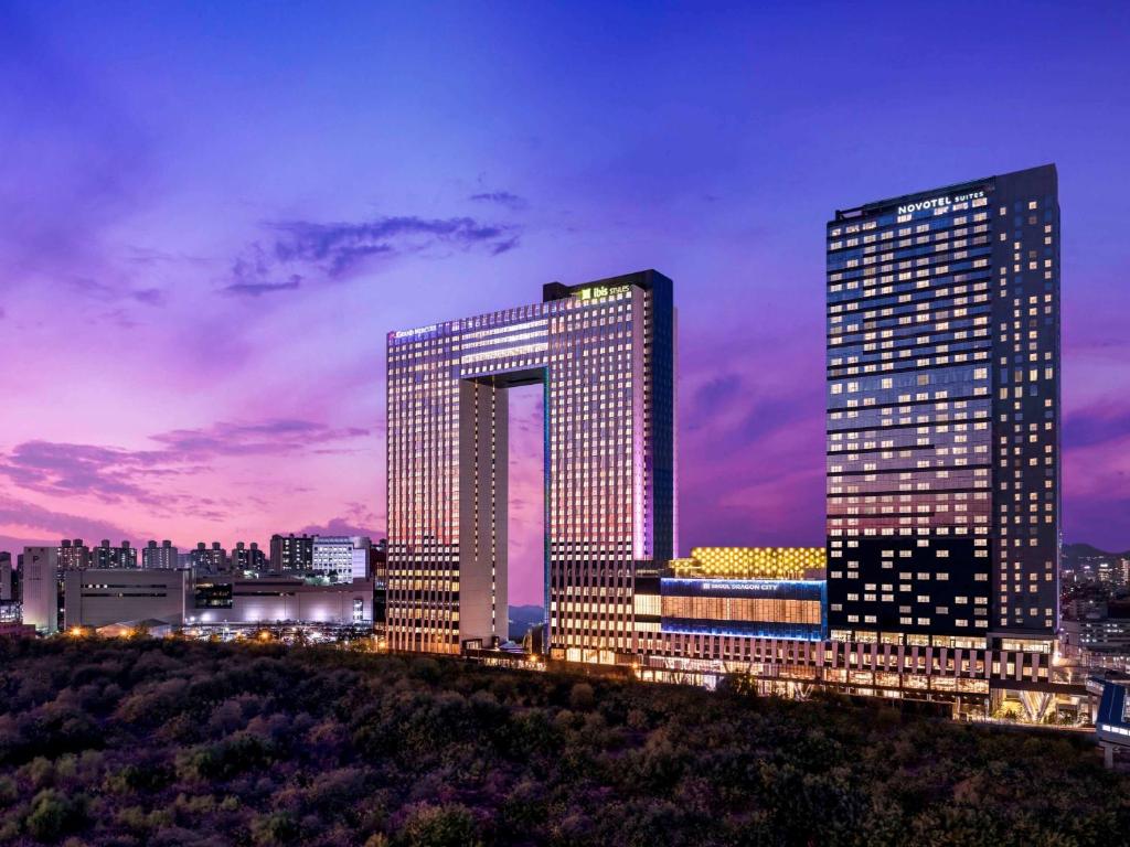 two tall buildings in a city at night at ibis Styles Ambassador Seoul Yongsan in Seoul