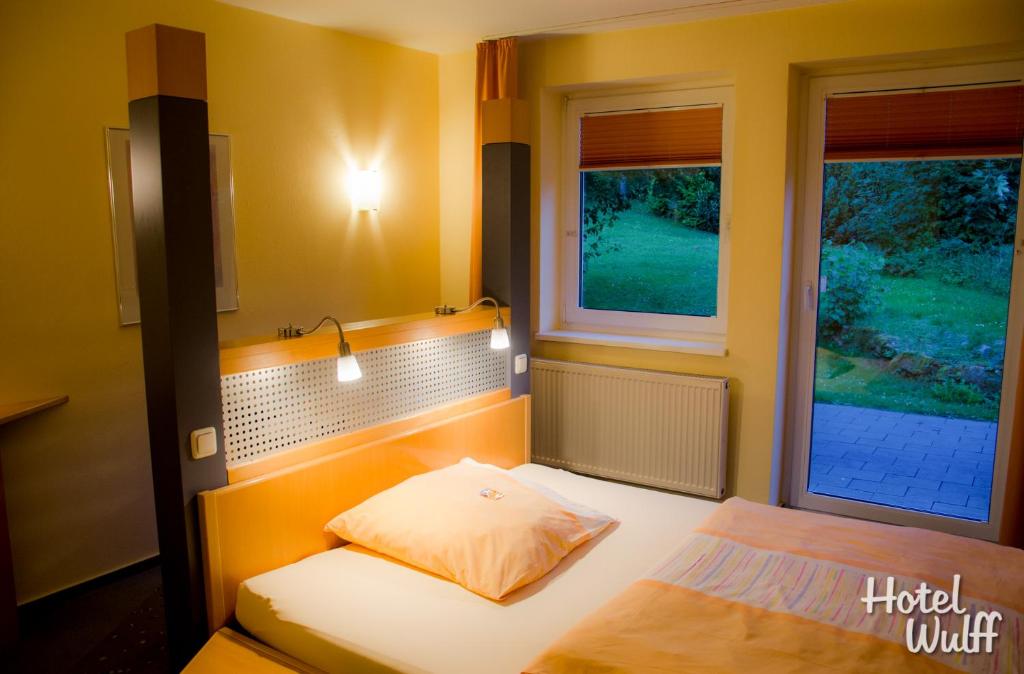a small bedroom with a bed and a window at Hotel Wulff in Warburg