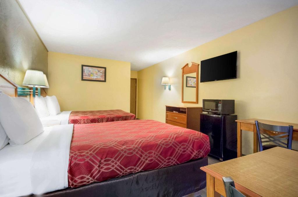 pokój hotelowy z 2 łóżkami i stołem w obiekcie Econo Lodge Lansing - Leavenworth w mieście Lansing