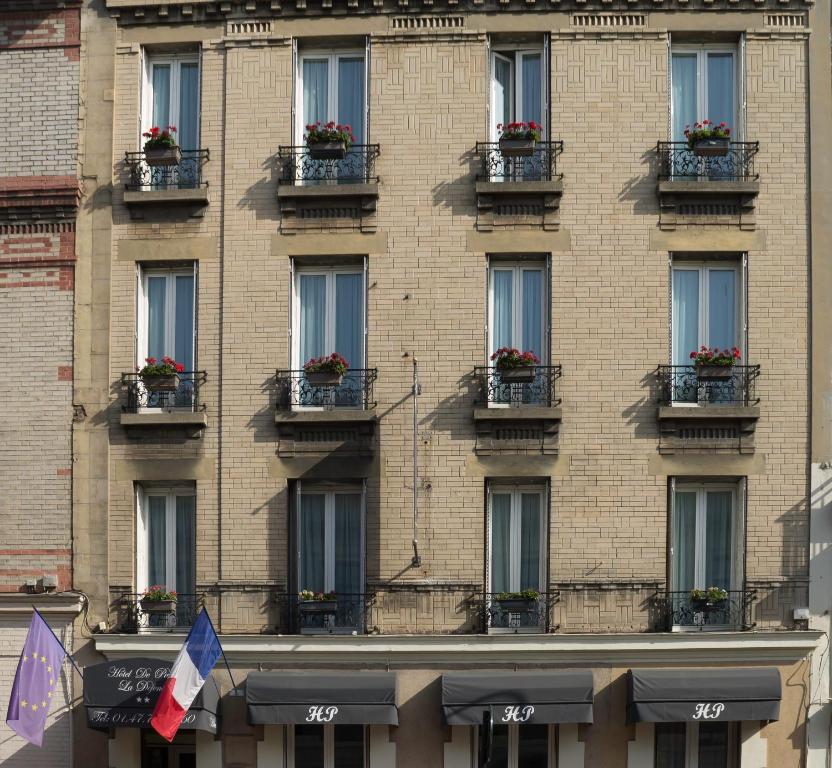 a tall brick building with windows with flower boxes at Hôtel de Paris La Défense in Puteaux