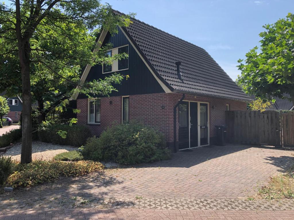 een rood bakstenen huis met een zwart dak bij 't Hulzen 55 or 61 Winterswijk in Winterswijk