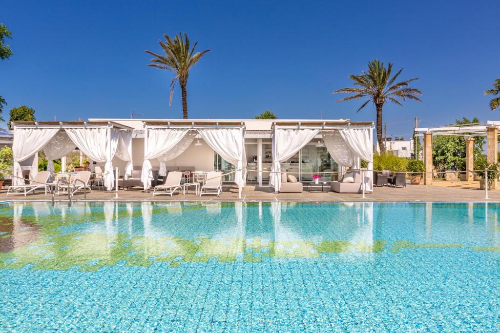 a swimming pool in front of a resort at Tenuta Terenzano in Torre San Giovanni Ugento