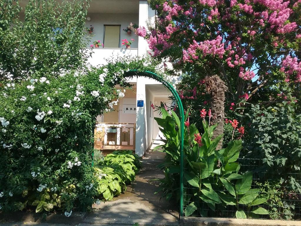 um arco num jardim com flores e plantas em Apartment Mirjana em Fažana