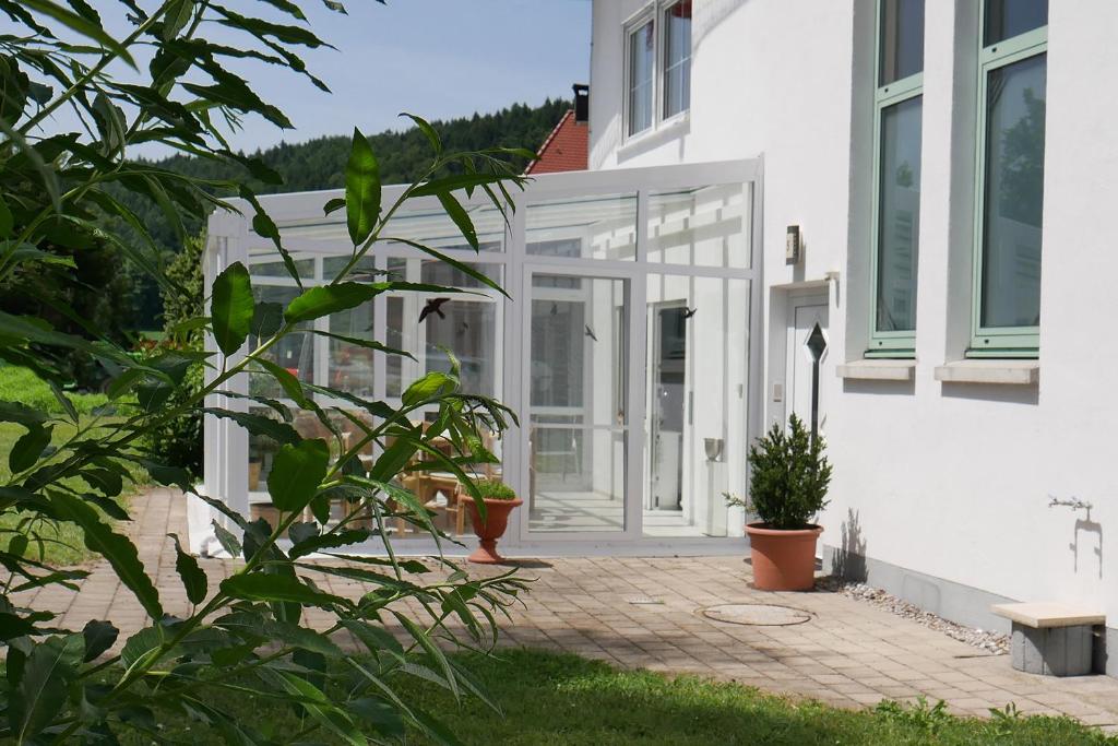 an extension to a house with glass doors at Ferienhaus/Ferienwohnung BeeHappy in Aichstetten