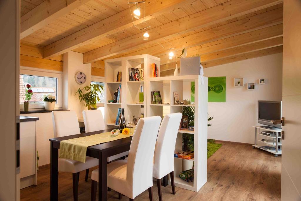 ein Esszimmer mit einem Tisch und weißen Stühlen in der Unterkunft Ferienwohnung Hanne in Untrasried