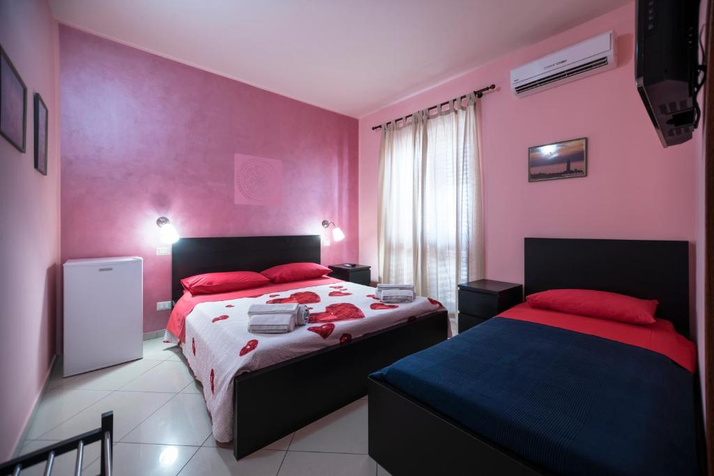 een slaapkamer met 2 bedden en roze muren bij Sun and Beach in Catona