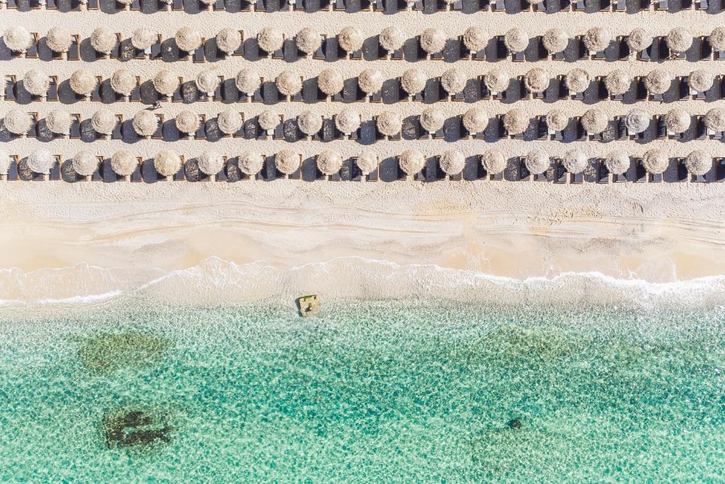an aerial view of a beach with a group of umbrellas at Elia Mykonos Resort in Elia Beach