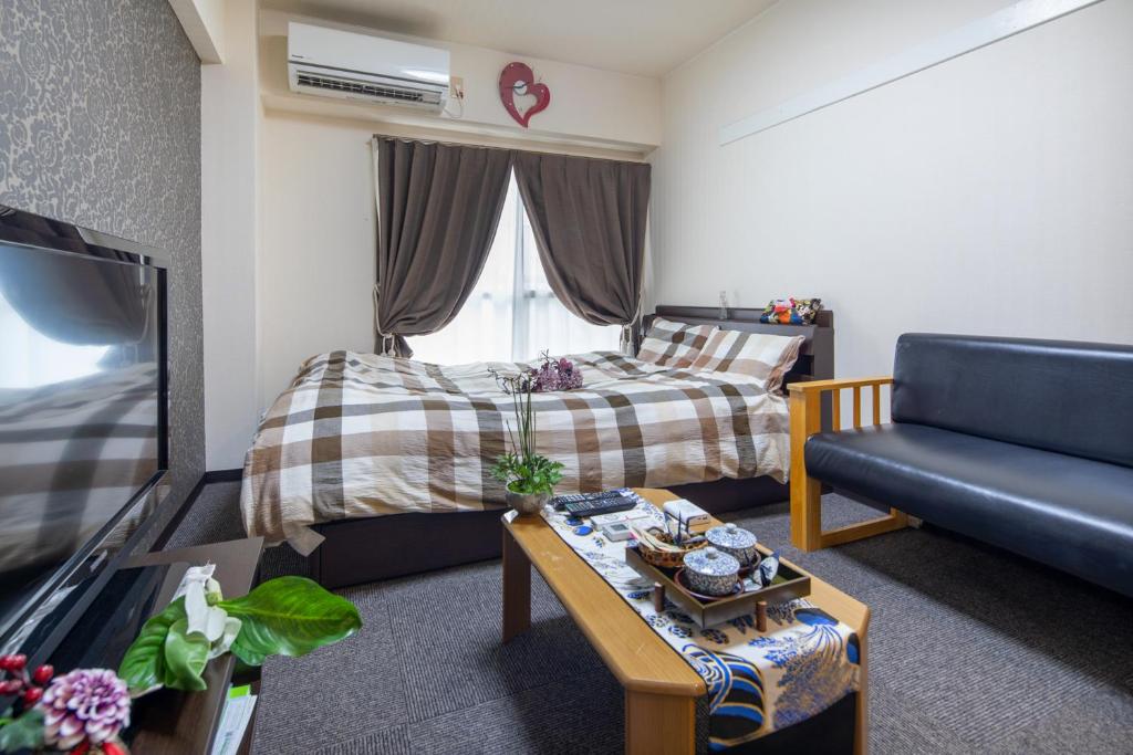 een woonkamer met een bed en een bank bij Cozy house 8, free wifi a rented electric bicycle in Kyoto