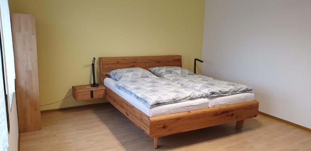 ein Schlafzimmer mit einem Holzbett und einem Nachttisch in der Unterkunft Gästezimmer Junglas in Bornheim