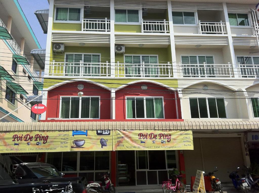 un edificio con un cartel para una tienda de perritos calientes en Poi De Ping, en Chiang Mai
