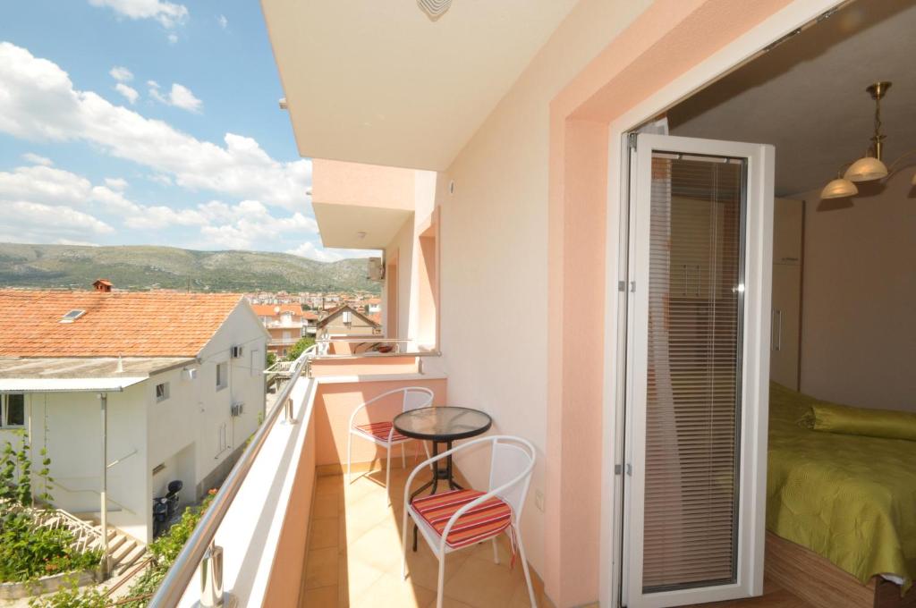 um quarto com uma varanda com uma cama e cadeiras em Apartments Belas em Trogir