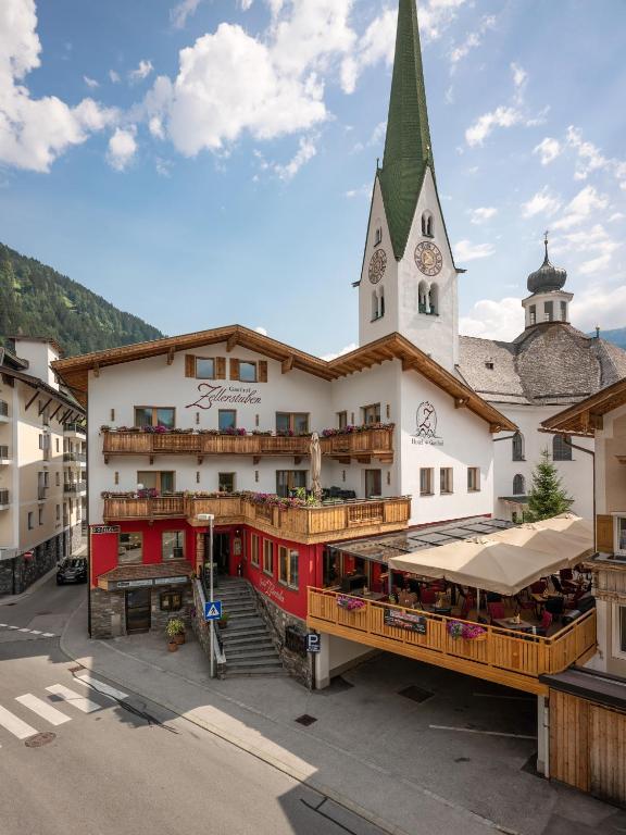 budynek z wieżą zegarową i kościołem w obiekcie Gasthof Zellerstuben w mieście Zell am Ziller