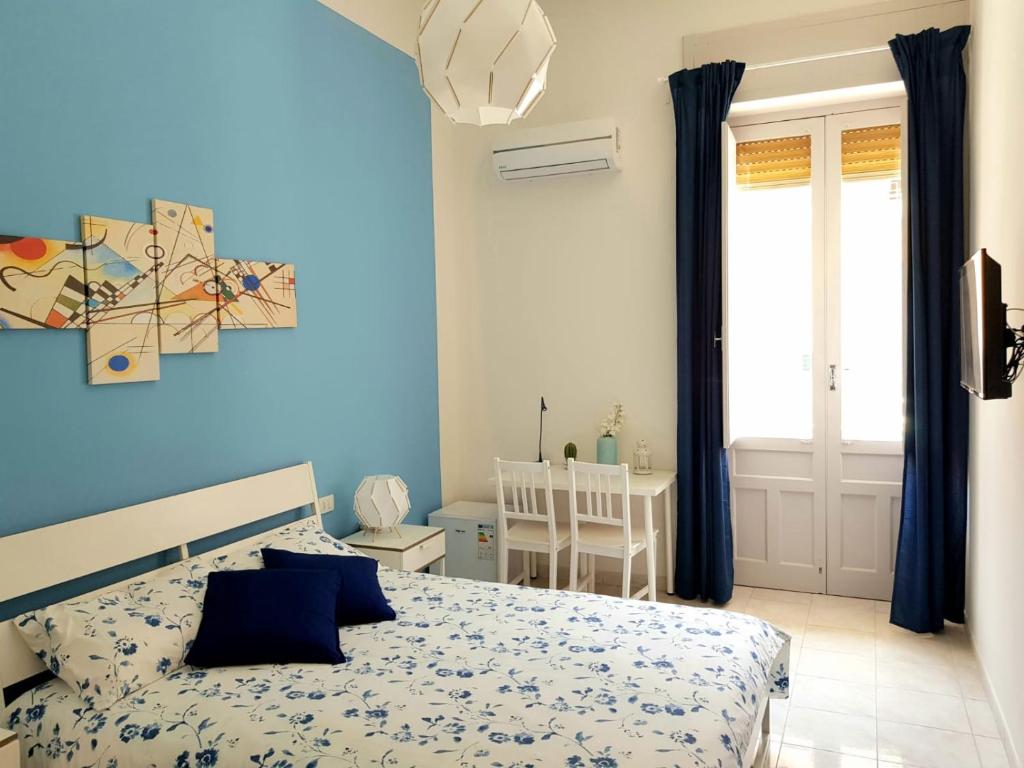 Dormitorio azul con cama y mesa en L'Opera dei Pupi B&b, en Avola