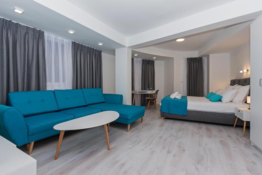 a living room with a blue couch and a bed at Casa di VaLL City Apartments in Ohrid