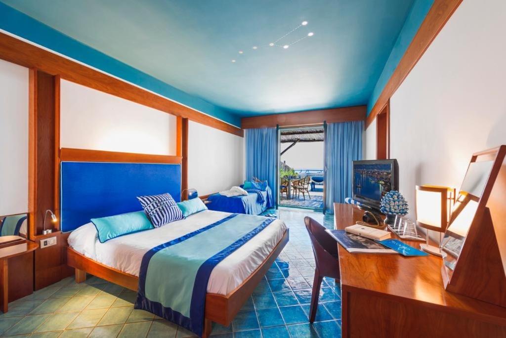 馬薩盧布倫塞的住宿－羅司考格里奧酒店，一间卧室配有一张床、一张书桌和一台电视