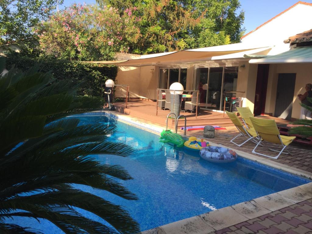 uma piscina com um macarrão de piscina num quintal em Loft, avec piscine privative et parking, à 15 minutes à pied du centre ville et à 20 mn de la mer em Montpellier