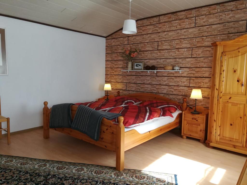 a bedroom with a wooden bed and a brick wall at Ferienhaus am Park in Diez