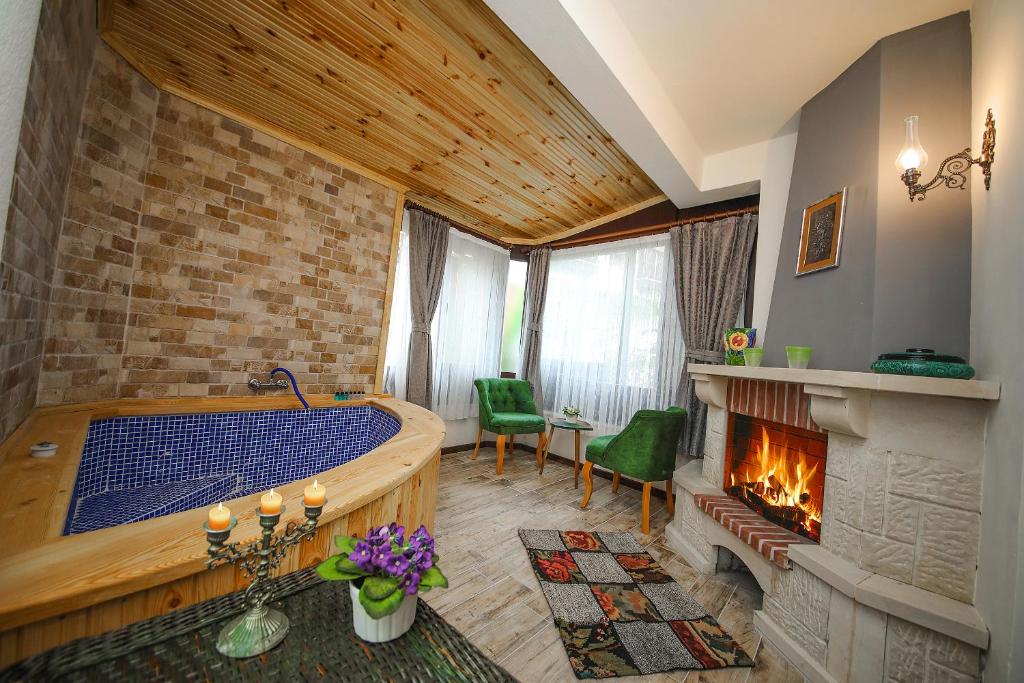 a living room with a tub and a fireplace at Ağva Deniz Yıldızı Otel in Ağva