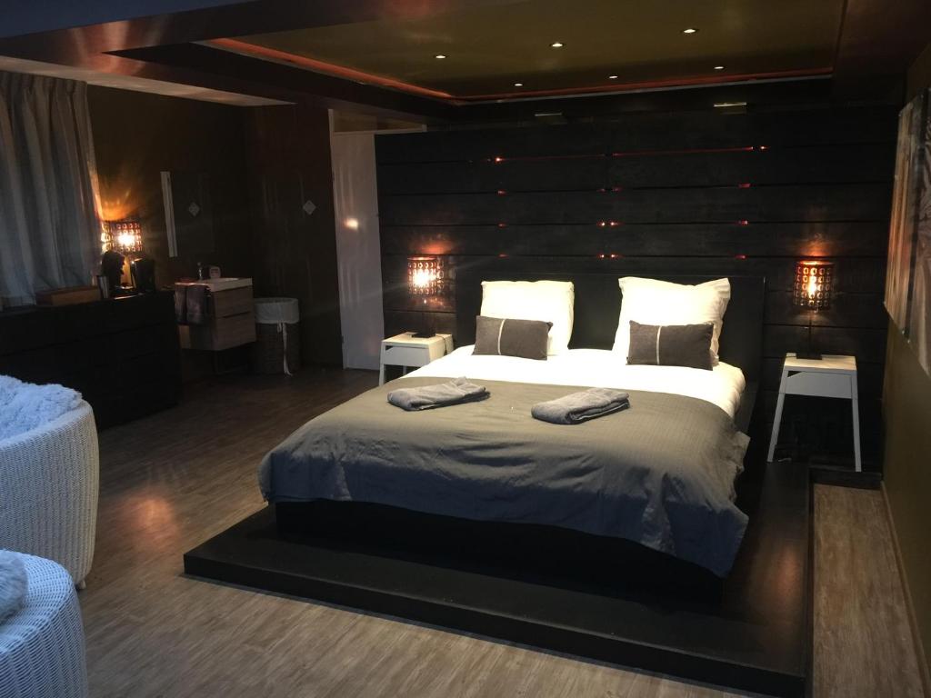 a bedroom with a large bed with a wooden headboard at Suite & Wellness in Breskens
