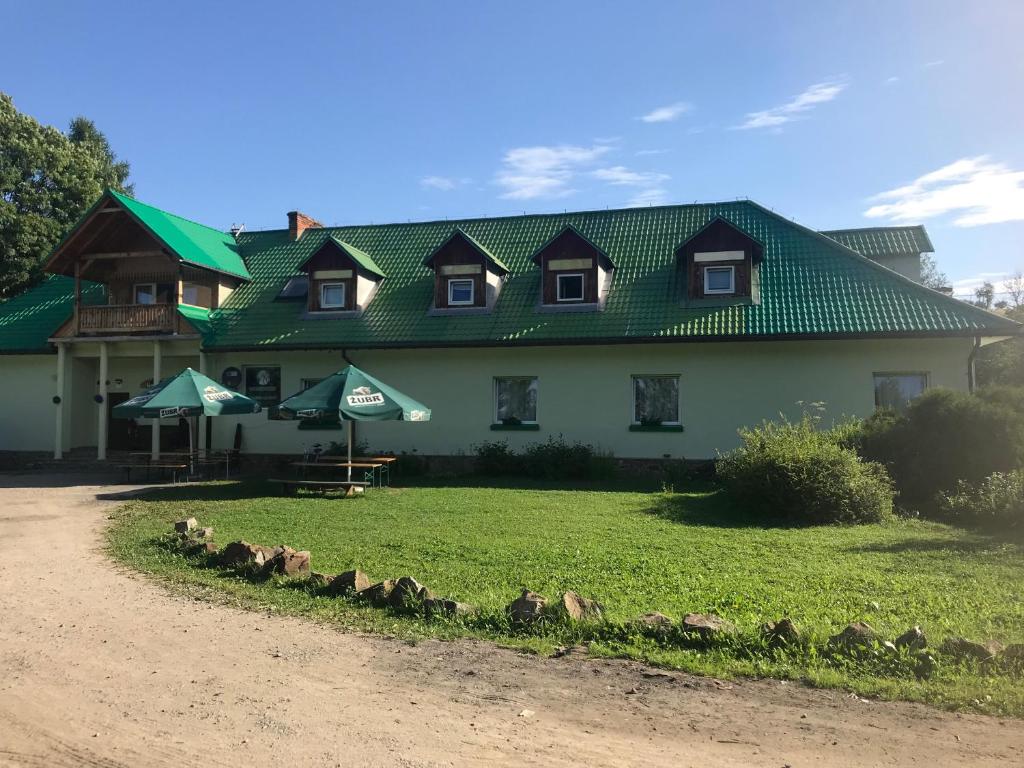 a large white house with a green roof at Latarnia Wagabundy Bieszczady in Wola Michowa