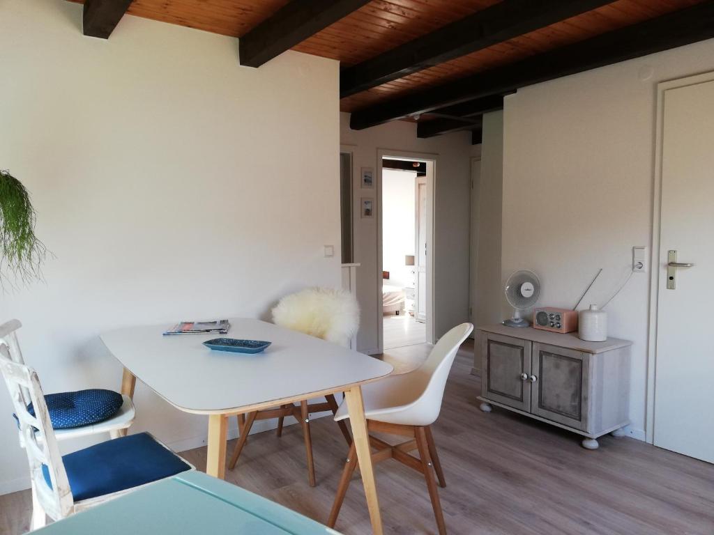 Un comedor con una mesa y sillas blancas. en FW Achterdeck, 1 Obergeschoss, Petershof-Lehbek, en Gelting