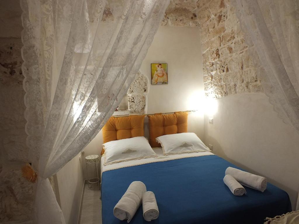 Schlafzimmer mit blauem Bett und weißen Vorhängen in der Unterkunft Casa Cuore di Pietra "STONEHEART HOME" in Ceglie Messapica