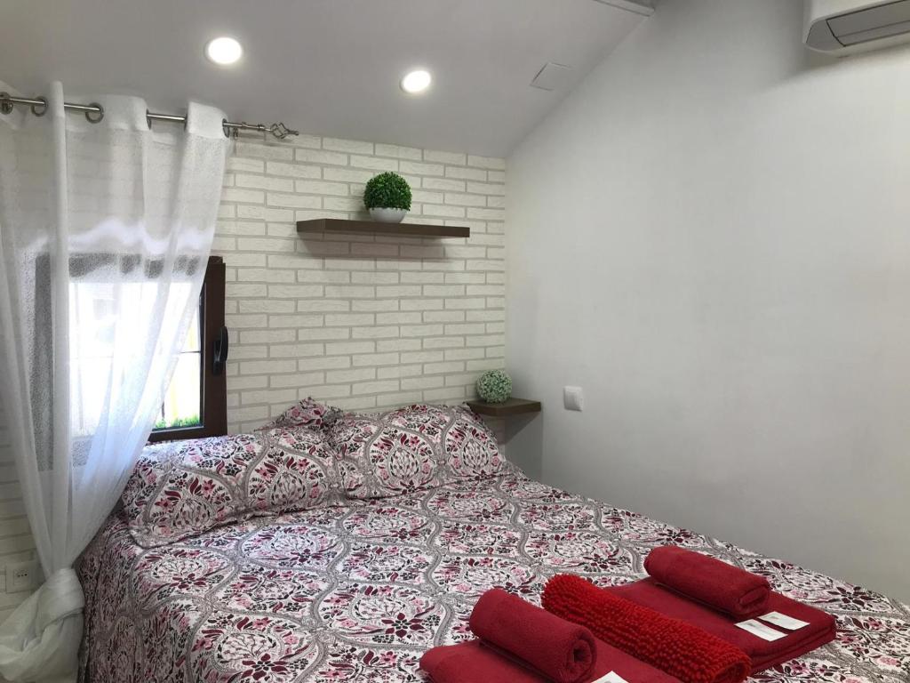 Un dormitorio con una cama con almohadas rojas. en CAPRICHO EN TOLEDO, en Toledo