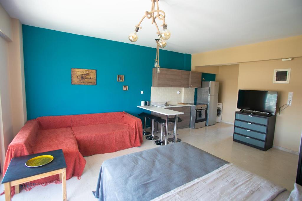 uma sala de estar com um sofá vermelho e uma parede azul em Joanna's studio (Rafina port) em Rafina