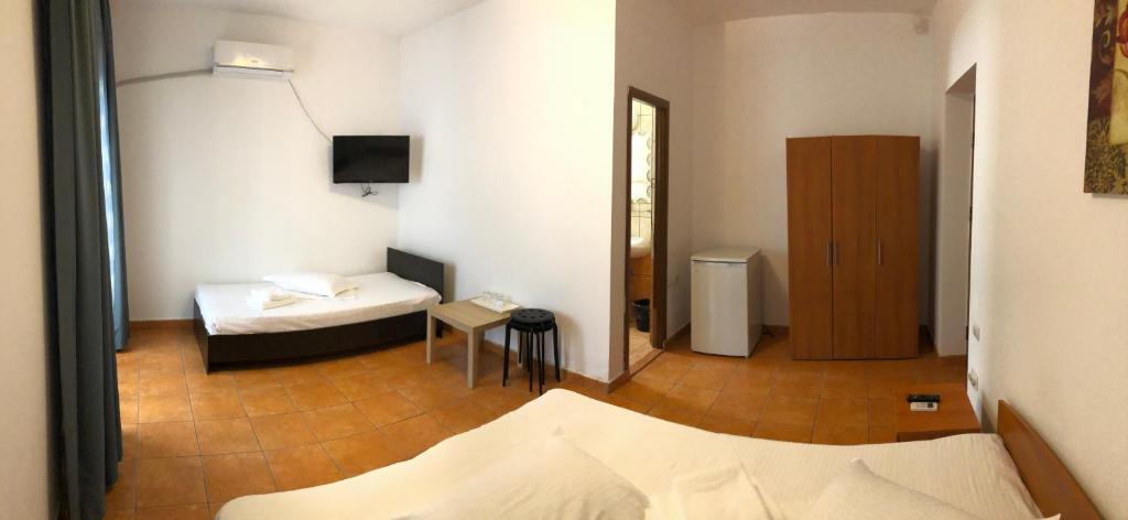 a room with two beds and a television in it at Vila Orient 2 in Eforie Nord