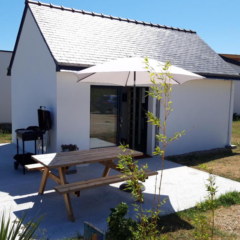- une table de pique-nique avec un parasol devant le bâtiment dans l'établissement Ty Breizh, à Erdeven