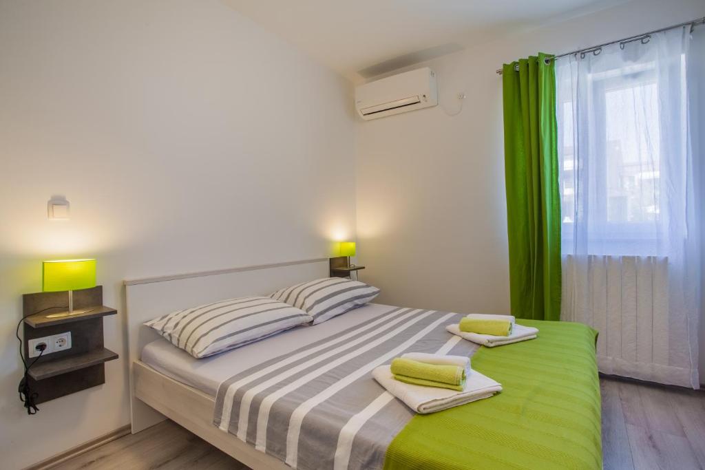 um quarto com uma cama grande e cortinas verdes em Room Elelina em Cres