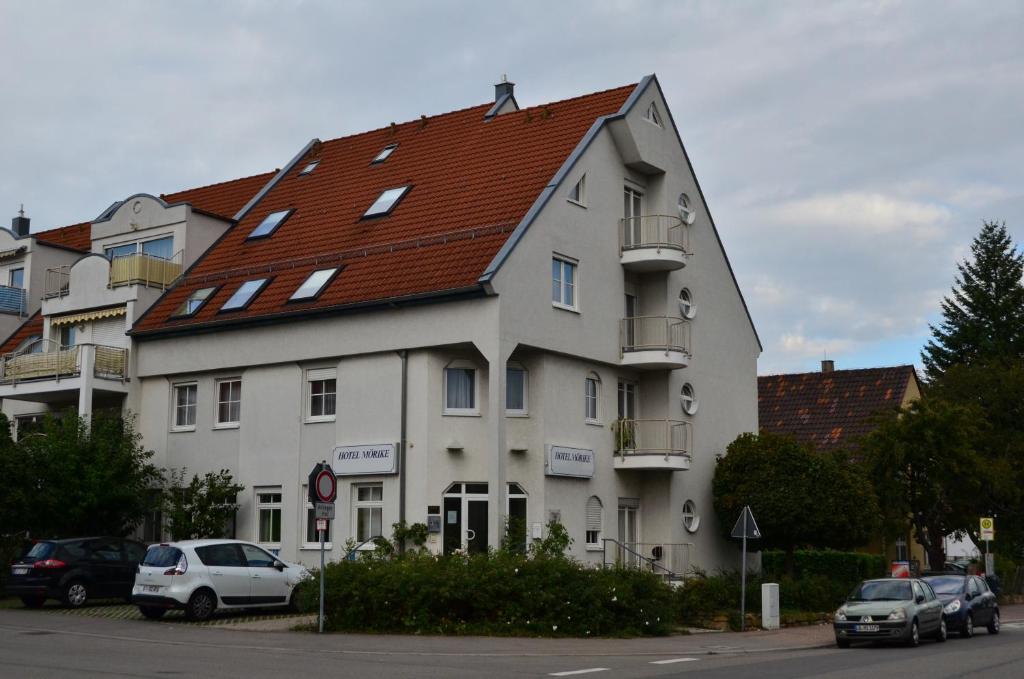 ein großes weißes Gebäude mit rotem Dach in der Unterkunft Hotel Mörike in Ludwigsburg