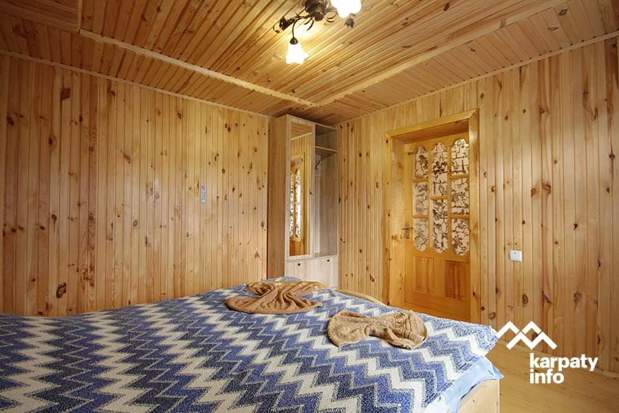 1 dormitorio con 1 cama en una habitación de madera en микуличин на долоні, en Mykulychyn