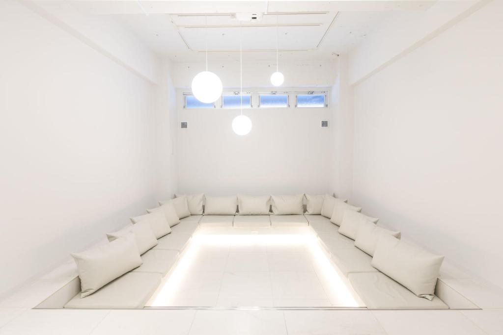 um quarto branco com cadeiras brancas e um sofá em TSUKIMI HOTEL em Quioto