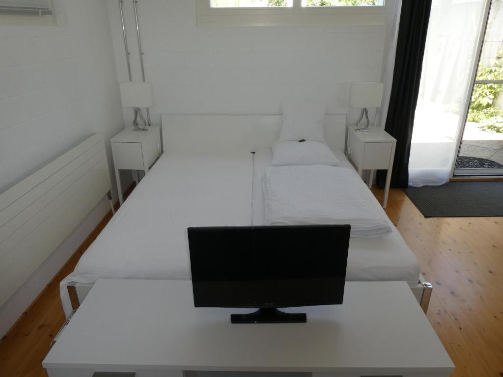 a room with three beds with a computer on a desk at B&B Elegant in Ueberstorf