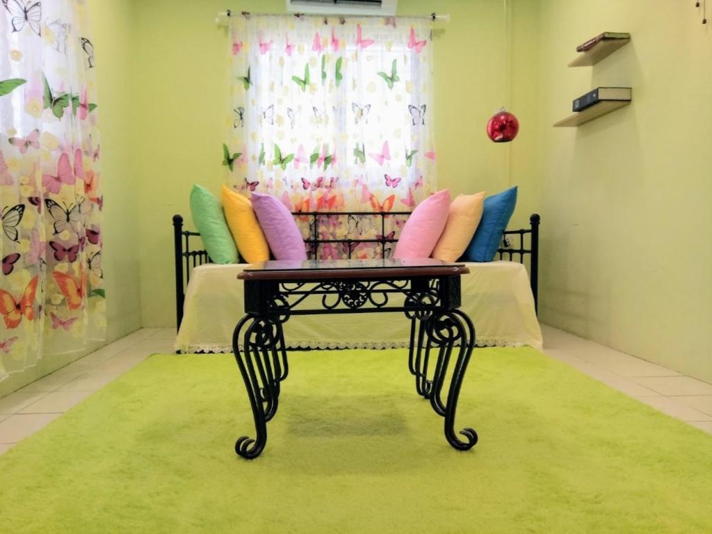Habitación con cama con almohadas coloridas y mesa. en 2 BR Medina Dollar Landed Homestay Cheras MRT Link, en Cheras