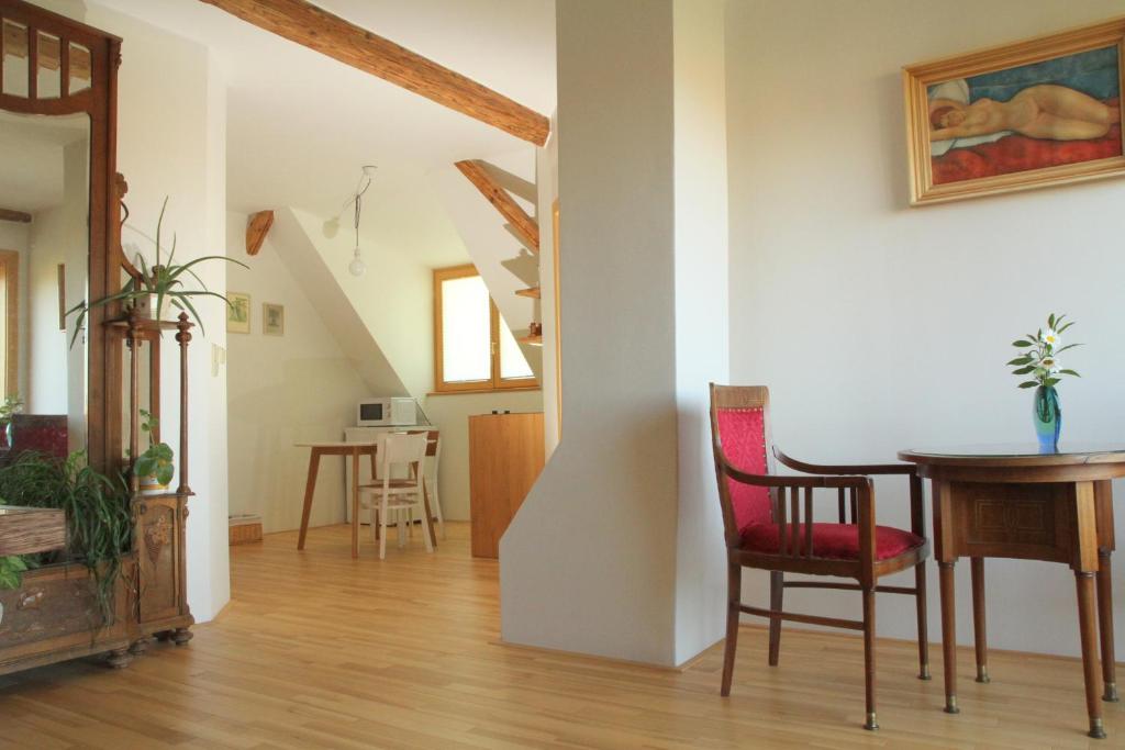 salon ze stołem, krzesłami i schodami w obiekcie Apartmán Nella w mieście Valtice