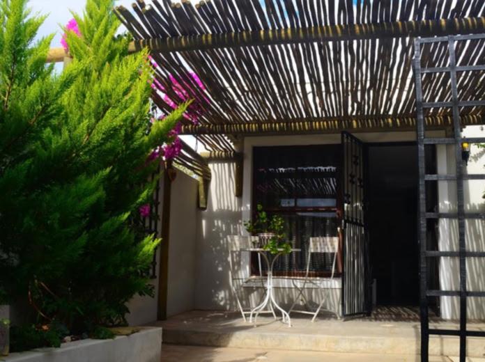 a patio with a pergola and a table and chairs at Peace Cottage in Montagu