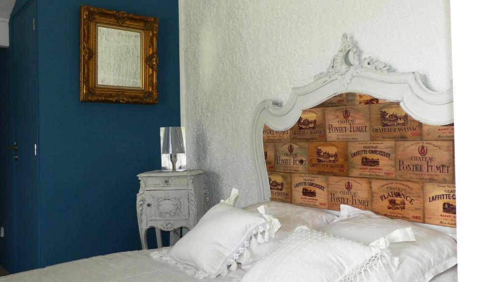 um quarto com uma cama com uma grande cabeceira branca em Bleuvelours em Andernos-les-Bains