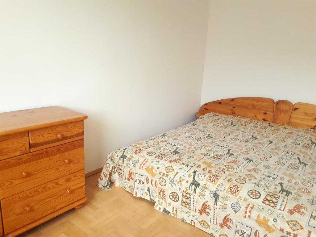 sypialnia z łóżkiem i drewnianą komodą w obiekcie Mieszkanie 3-pokojowe Gdańsk, ul. Rybna (2/4 piętro) w Gdańsku